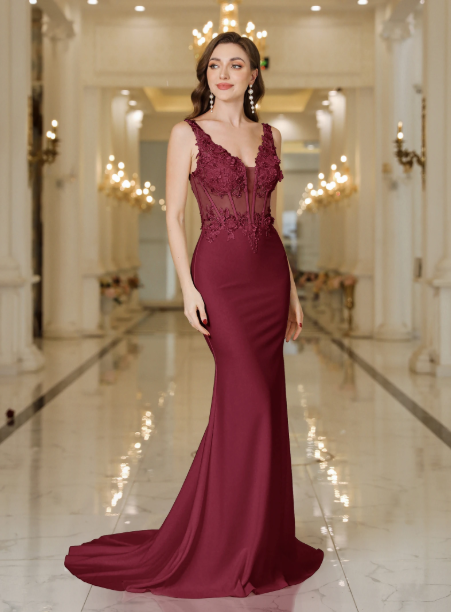Woman in a burgundy evening gown standing in an elegant hallway.